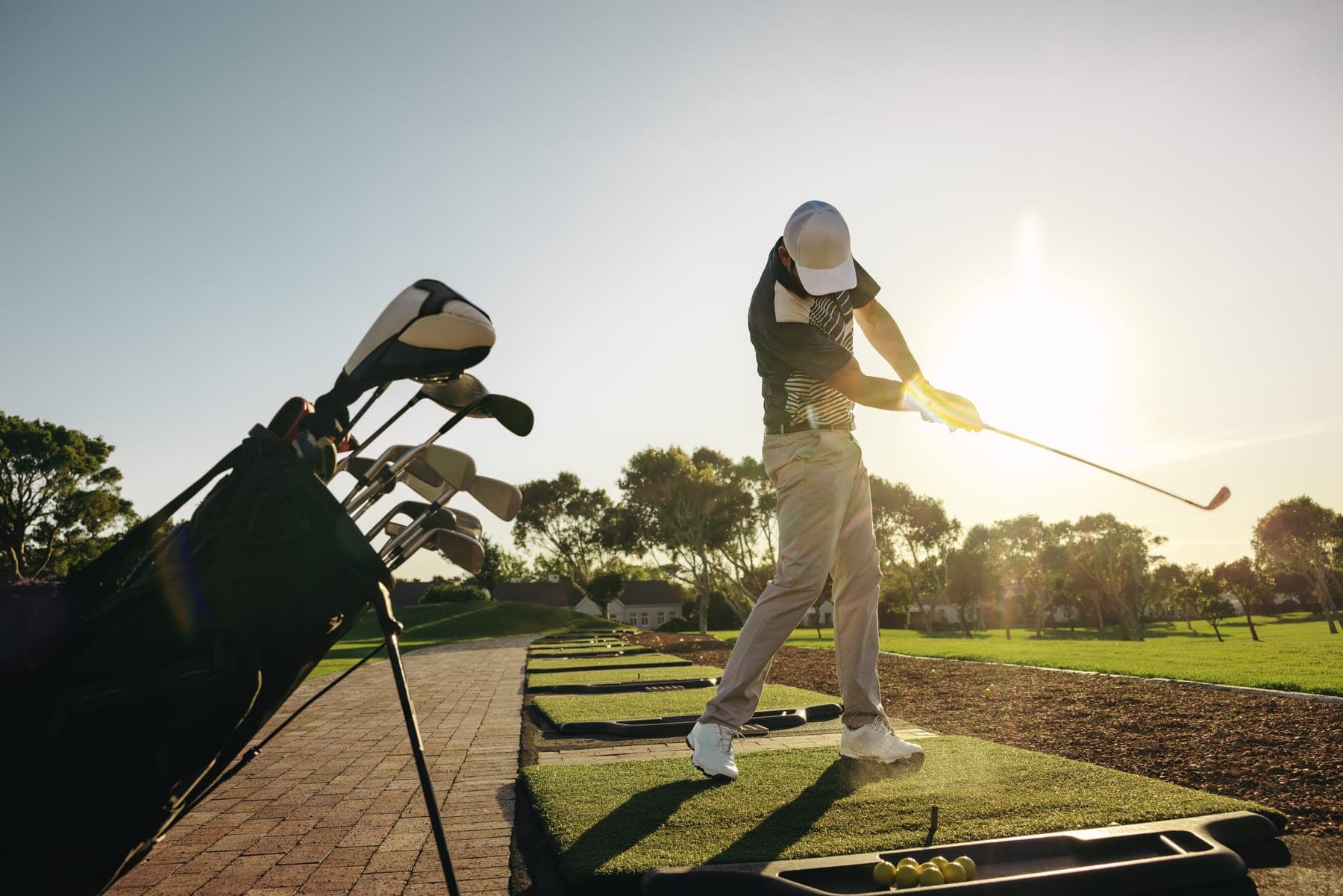 Golfer mid-swing at the driving range